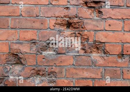 Dunkelbraune alte Ziegelwand mit ausgeschlaften Teilen Aufzählungspunkte Stockfoto