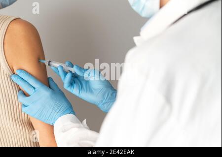 Nahaufnahme eines Arztes mit einer Spritze, die einen Impfstoff injiziert Stockfoto