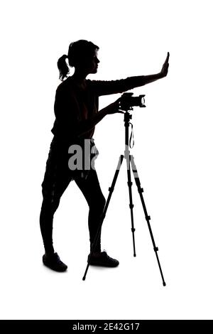 Silhouette eines Fotografen mit einer Kamera auf weißem Hintergrund isoliert für Verbundwerkstoffe. Sie wird mit einer Stop-Geste gestellt Stockfoto