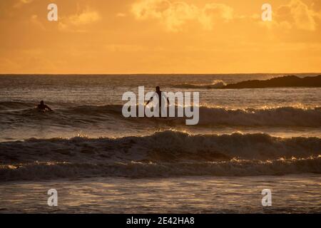 Swansea, Großbritannien. Januar 2021. Surfer reiten die Wellen, wenn die Sonne untergeht in Langland Bay in der Nähe von Swansea an diesem Nachmittag. PIC von Lisa Dawson Rees Kredit: Phil Rees/Alamy Live Nachrichten Stockfoto