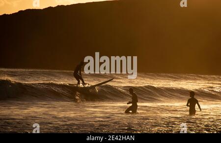 Swansea, Großbritannien. Januar 2021. Surfer reiten die Wellen, wenn die Sonne untergeht in Langland Bay in der Nähe von Swansea an diesem Nachmittag. PIC von Lisa Dawson Rees Kredit: Phil Rees/Alamy Live Nachrichten Stockfoto