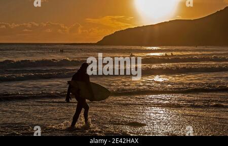 Swansea, Großbritannien. Januar 2021. Surfer reiten die Wellen, wenn die Sonne untergeht in Langland Bay in der Nähe von Swansea an diesem Nachmittag. PIC von Lisa Dawson Rees Kredit: Phil Rees/Alamy Live Nachrichten Stockfoto