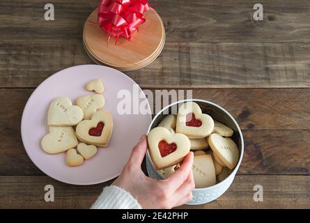 Herzförmige Kekse gefüllt mit Marmelade. Handgefüllte Plätzchenbox für Frauen. Speicherplatz kopieren. Stockfoto