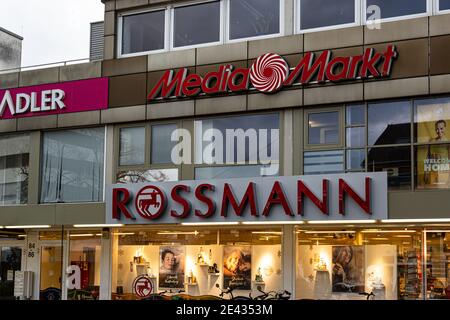 NEUWIED, DEUTSCHLAND - 29. Dezember 2020: Neuwied, Deutschland - 29. Dezember 2020: Fassade eines Einkaufszentrums mit Neonschildern für Geschäfte 'Media-Markt', 'Rossmann' Stockfoto