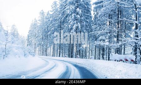 Snowy winter road in a mountain forest. Beautiful winter landscape. Stockfoto