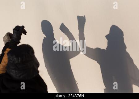 Ellenbogen Stoß Sicherheit Gruß von zwei Menschen Schatten an der Wand des Coronavirus COVID-19 Pandemie. Neuer Normalwert. Stockfoto