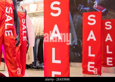 Inschrift Verkauf auf dem Hintergrund einer roten Glaswand im Laden. Rabattankündigung Für Das Einkaufszentrum. Sommer, Winter Weihnachten, Neujahr Sale.Sale rote Zeichen Stockfoto