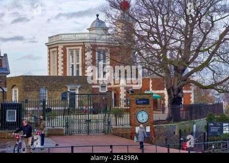 Leute, die vor dem Eingang des Londoner Observatoriums, Greenwich Mean Time, England, Peddle Bikes schieben Stockfoto