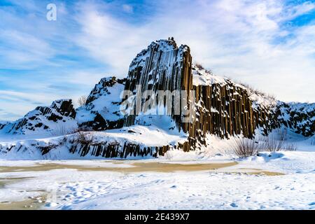 Panska skala - Gesteinsbildung von fünfeckigen und sechseckigen Basaltsäulen. Sieht aus wie riesige Orgelpfeifen. Im Winter von Schnee und Eis bedeckt. Kamenicky Senov, Tschechische Republik. Stockfoto