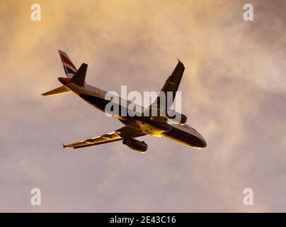 London, England - Oktober 2018: British Airways Airbus A320 nach dem Start gegen den Sonnenuntergang Stockfoto