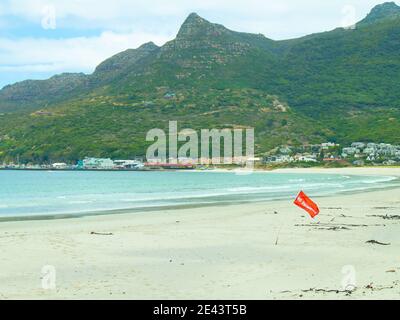 Hout Bay- Kapstadt, Südafrika - 19-01-2021 leuchtend rote 'No Swimming' Flagge weht im Wind am Hout Bay Strand. Stockfoto