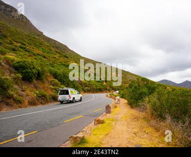 Chapman's Peak - Kapstadt, Südafrika - 19-01-2021 kurvige Straße auf Chapmans Peak Drive. Autos fahren langsam vorbei. Stockfoto