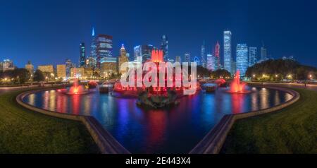 Panoramablick auf die Stadt mit dem berühmten Buckingham Fountain, der von bunten Lichtern beleuchtet wird Gegen moderne Wolkenkratzer in der Nacht in Chicago Stockfoto