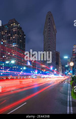 NEW YORK, EEUU - 21. September 2018 - lange Exposition der beleuchteten Straße mit Ampeln und Blick auf landmarkierte Flatiron Gebäude Fassade gegen da Stockfoto