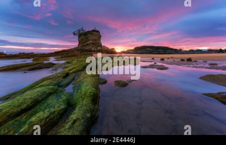 Spektakuläre Landschaft von Urros de Costa Quebrada mit rauen felsigen Formationen von Meereswellen unter dramatischen Sonnenuntergang Himmel mit gewaschen Dunkle Wolken am Abend t Stockfoto