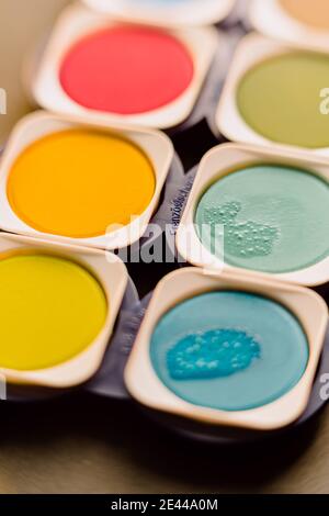 Oben Nahaufnahme der hellen bunten Aquarellfarben mit den Spuren Der Bürste in der Box angeordnet Stockfoto