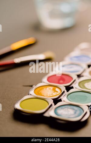 Helle bunte Aquarellfarben mit Pinsel und Spuren von Pinsel In Box angeordnet Stockfoto