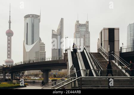 Niedriger Winkel Blick auf zeitgenössische geometrische Hochhäuser und Fußgängerbrücke auf der Straße von Bund im Zentrum von Shanghai Stockfoto