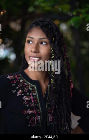 Portrait einer verträumten attraktiven afro latina Frau mit Dreadlocks, die nach oben schauen Stockfoto