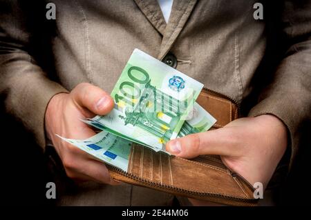 Geschäftsmann Hände halten Brieftasche mit Stapel von Euro Scheine Geld Isoliert auf Schwarz Stockfoto