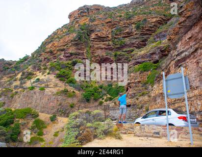 Chapman's Peak - Kapstadt, Südafrika - 19-01-2021 der Mann fotografiert den felsigen Berg auf der Seite des Chapmans Peak Drive. Stockfoto