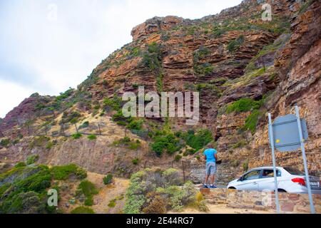 Chapman's Peak - Kapstadt, Südafrika - 19-01-2021 der Mann fotografiert den felsigen Berg auf der Seite des Chapmans Peak Drive. Stockfoto