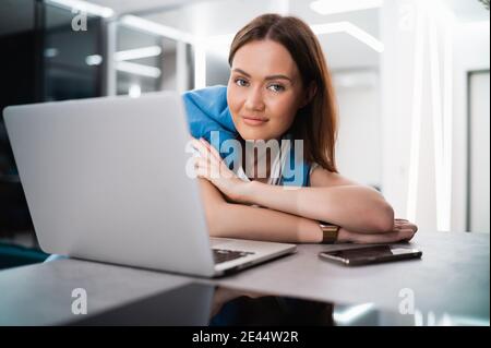 Frau auf Remote-Arbeit oder Online-Bildung, mit Laptop-Computer, Notizen machen, drinnen zu Hause. Online-Geschäft, junge Berufstäige am Arbeitsplatz Stockfoto