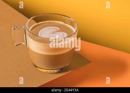 Glas Tasse frischen heißen aromatischen Cappuccino mit Latte Art In Herzform auf dem Tisch serviert Stockfoto