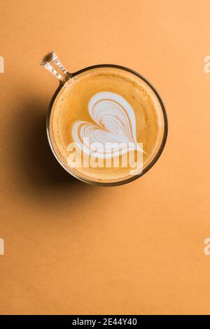 Glas Tasse frischen heißen aromatischen Cappuccino mit Latte Art In Herzform auf dem Tisch serviert Stockfoto
