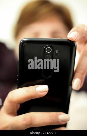 Vertikale selektive Fokusaufnahme der weiblichen Hände mit einem Phon Stockfoto