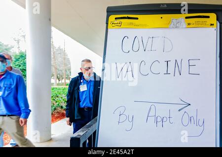 Krankenhauspersonal geht an einem Schild vorbei, das Patienten zum COVID-19-Impfstoffverteilungszentrum im Providence Hospital in Mobile, Alabama, führt. Stockfoto