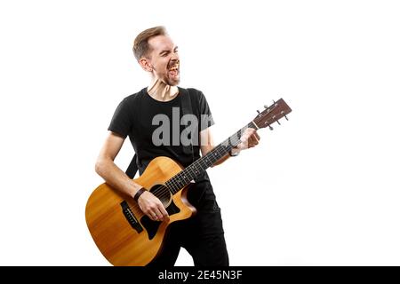 Der junge Mann spielt Gitarre. Isolierter weißer Hintergrund Stockfoto