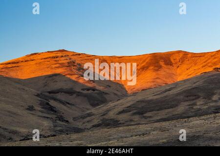 Sonnenuntergang auf den grasbewachsenen Hügeln in der Nähe von Feldern und Frenchglen, Oregon, USA Stockfoto