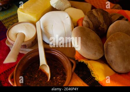 Traditioneller mexikanischer Tisch mit Käse, Brot, würziger Salsa und Crema. Stockfoto