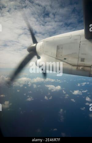 Flugzeugpropeller auf dem Flügel gegen einen bewölkten Himmel Und über den Ozean Stockfoto