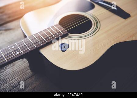 Gitarre ruht auf altem Holzhintergrund, Close Up Akustikgitarre und Gitarre Pick Stockfoto