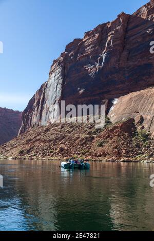 Eine Gruppe von Menschen, die nicht erkennbar sind, schwimmt an einem sonnigen Tag auf dem Colorado River im Glen Canyon auf einem Gummiboot. Stockfoto