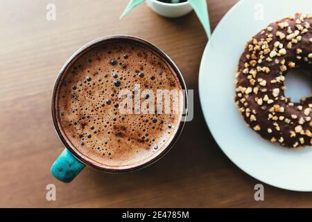 Donuts auf dem weißen Teller und Kaffee auf dem Holz Tabelle Stockfoto