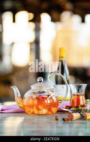 Transparente Frucht Teekanne und Teetasche, Weinflasche und Kork steht auf dem Tisch Stockfoto