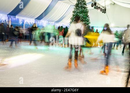 Malaga, Spanien - 08. Dezember 2017. Viele Menschen Schlittschuh auf große Eisbahn in der Winternacht, Bewegungsunschärfe Stockfoto