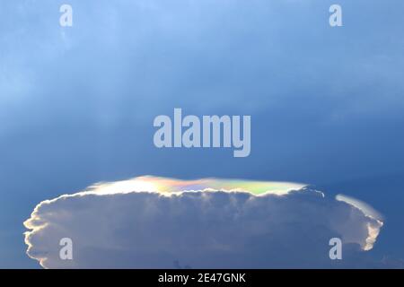 Wolken, die pilzähnliche Kreise bilden und überall Regenbogenfarbene Lichter erscheinen. Stockfoto