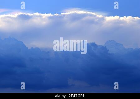 Wolken, die in wechselnden Schichten schwimmen, ähnlich wie Wasserfärbung. Stockfoto