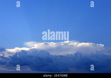 Wolken, die in wechselnden Schichten schwimmen, ähnlich wie Wasserfärbung. Stockfoto