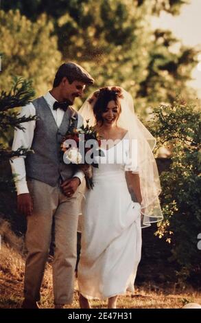 FRESNO, VEREINIGTE STAATEN - Jan 06, 2021: Ein Foto von einem glücklichen jungen Paar an ihrem Hochzeitstag tragen Vintage-Kleidung draußen Stockfoto