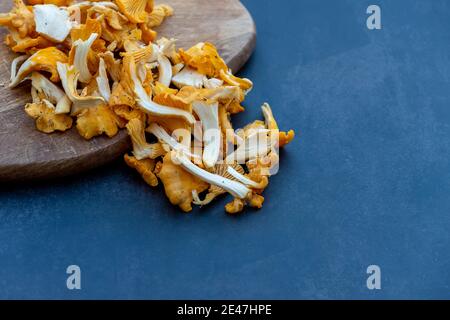 Frisch gepflückte, gelb-goldene Pfifferlinge, gereinigt, auf Schneidebrett geschnitten. Stockfoto