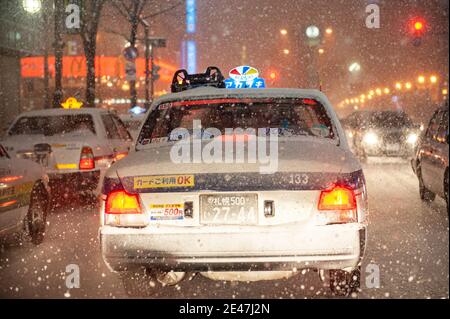 Japanische Taxis blieben in einer verschneiten Nacht im Verkehr stecken. Stockfoto