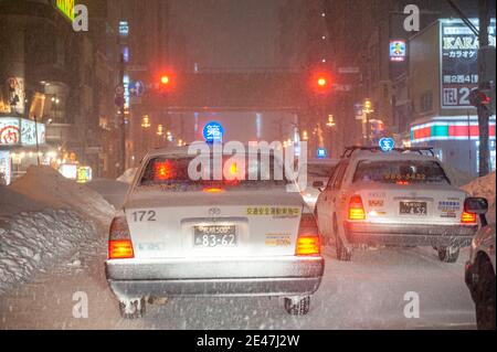 Japanische Taxis blieben in einer verschneiten Nacht im Verkehr stecken. Stockfoto