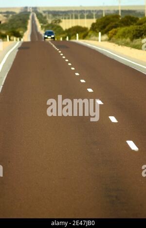 STRASSENMARKIERUNG AUF DEM EYRE HIGHWAY, DER SOUTH AUSTRALIA UND WESTERN AUSTRALIA VERBINDET. Stockfoto