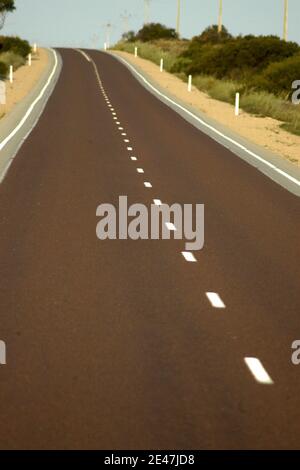 STRASSENMARKIERUNG AUF DEM EYRE HIGHWAY, DER SOUTH AUSTRALIA UND WESTERN AUSTRALIA VERBINDET. Stockfoto