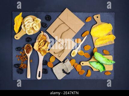Verschiedene getrocknete Früchte in Öko-Paket. Konzept der Öko-Pakete von Wertstoffen. Getrocknete Aprikosen, Rosinen, Mango, Papaya, Pflaumen, Banane. Stockfoto
